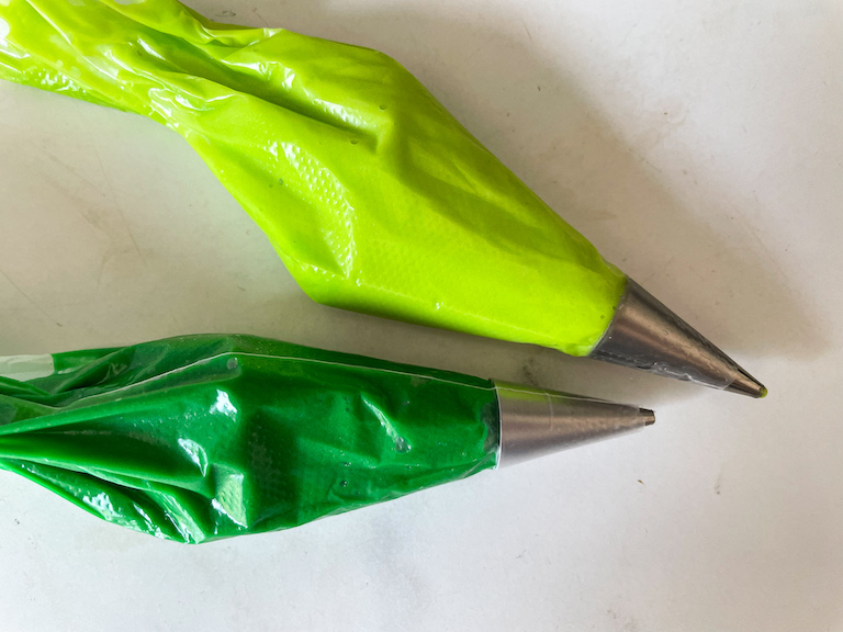 Two piping bags with green icing