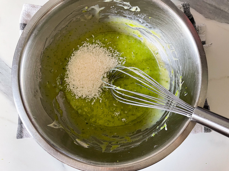 Adding shredded coconut to a bowl of ganache