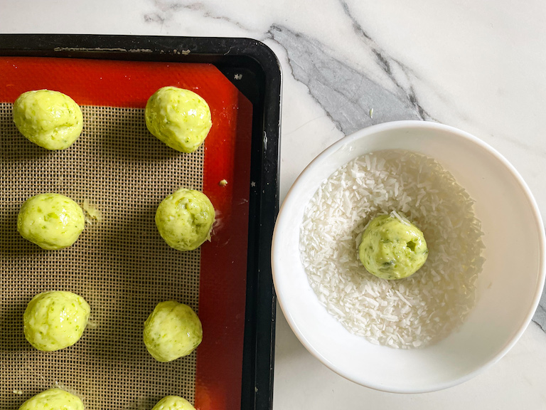 Lime chocolate truffles on a tray and a dish of shredded coconut