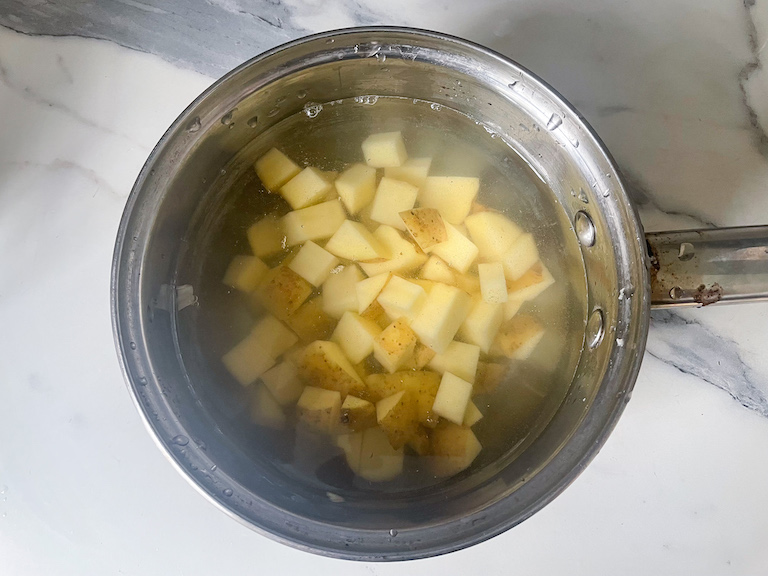 A pot of diced potatoes in water