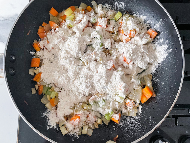 Adding flour to pot pie vegetable filling