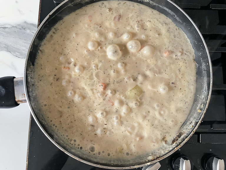 Creamy filling for meatless pot pie in a pan on a stovetop