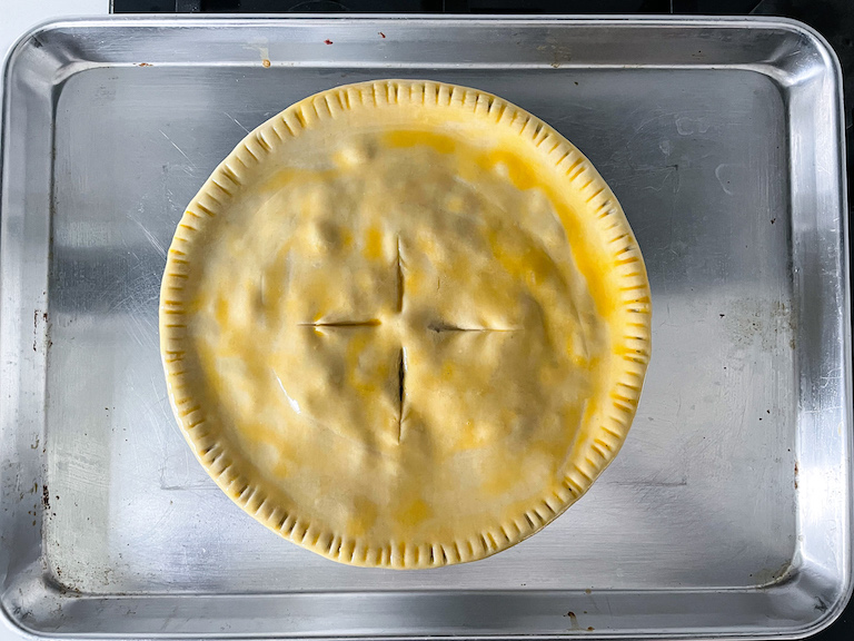 Unbaked pot pie on a metal tray