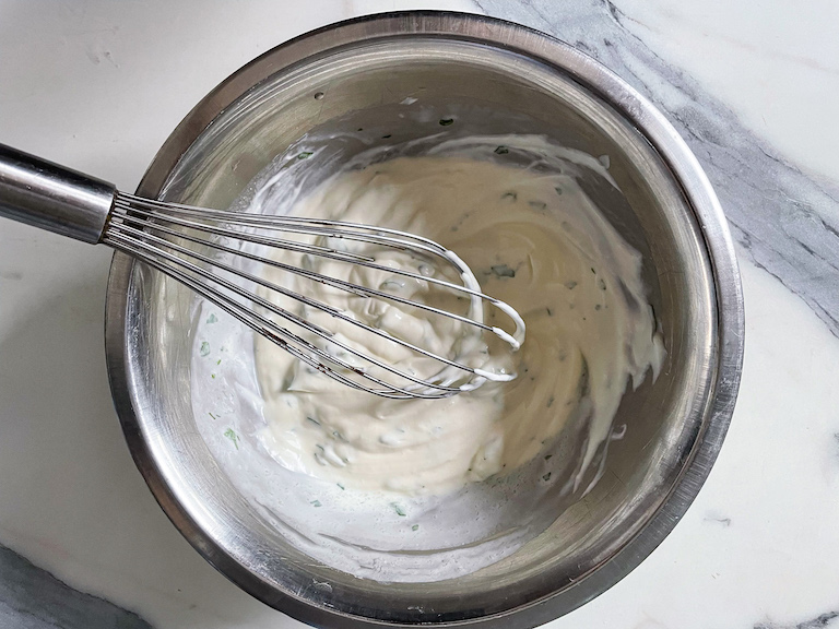 Blue cheese dip in a bowl with a whisk