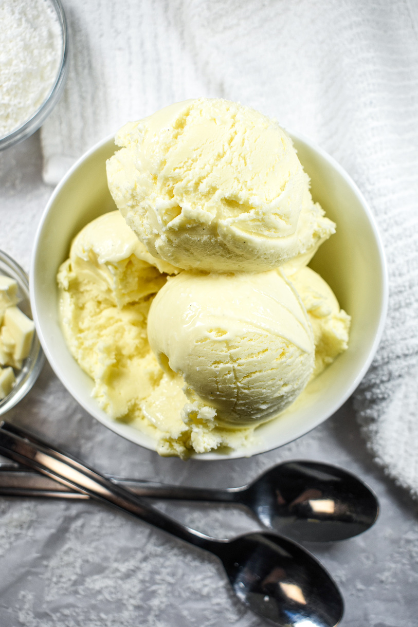 scoops of white chocolate coconut ice cream in a bowl with two spoons