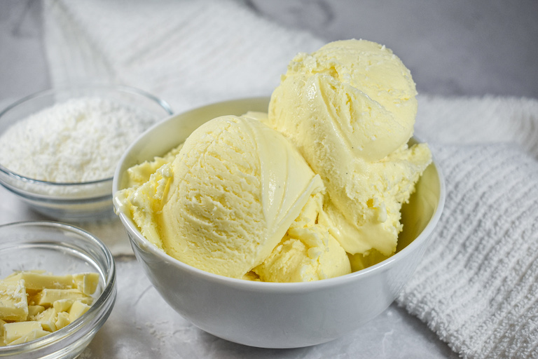 Dish of coconut ice cream, dish of white chocolate, and dish of shredded coconut