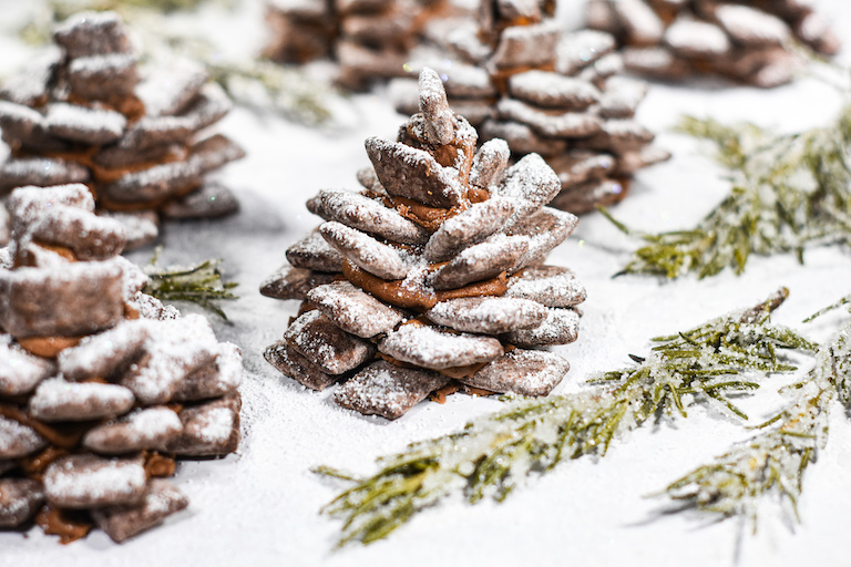 Chocolate pinecones and sugared rosemary on a white surface