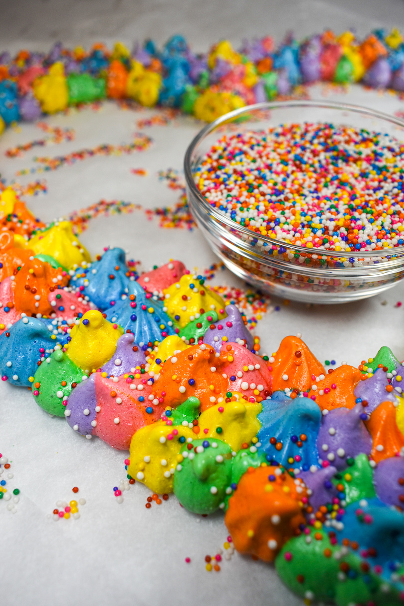 Piped rainbow meringue and a bowl of nonpareils