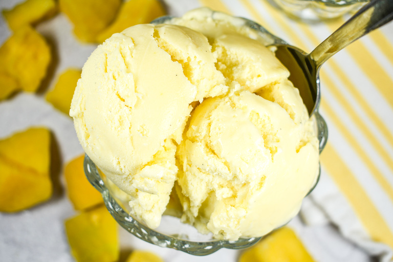 A dish of mango ice cream and a spoon