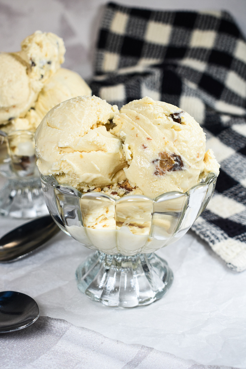 Glass dish of peanut butter ice cream and a checkered tea towel