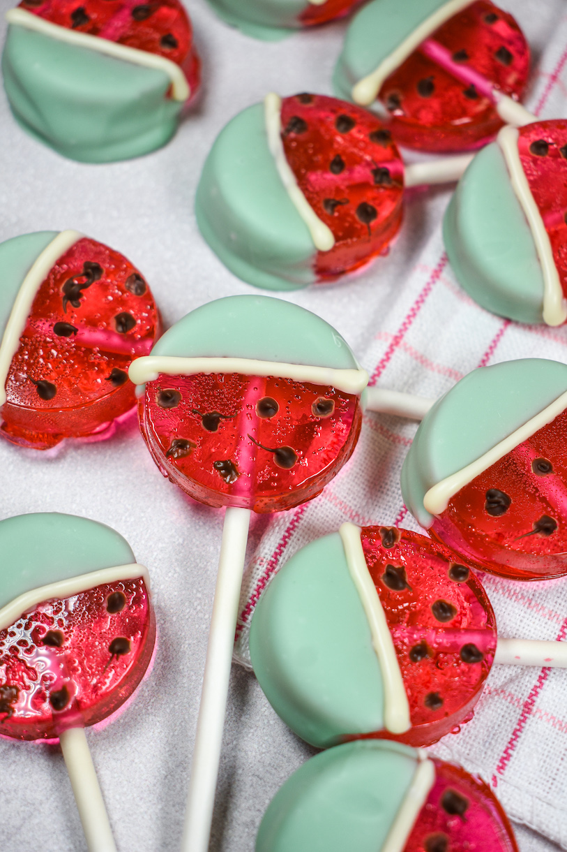 Watermelon lollipops on a white surface