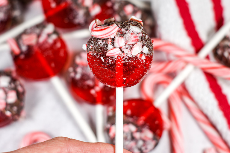 Hand holding a peppermint lollipop