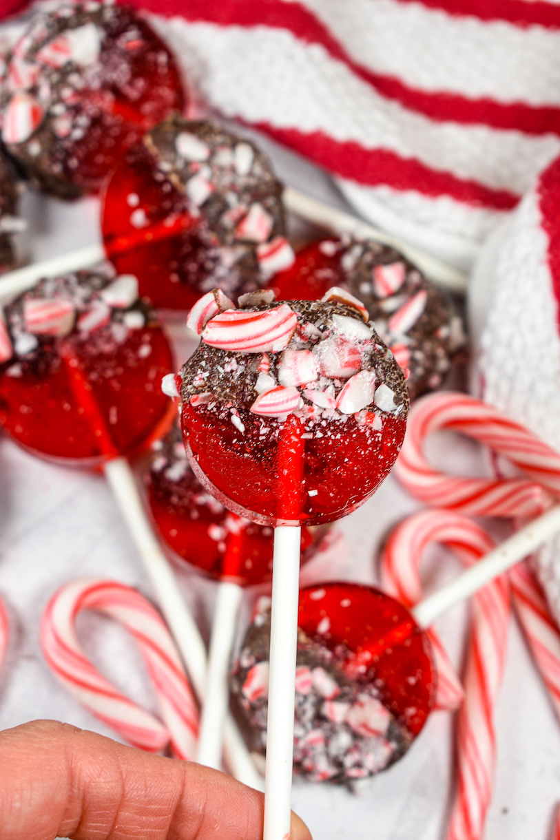 Hand holding a red Christmas lollipop