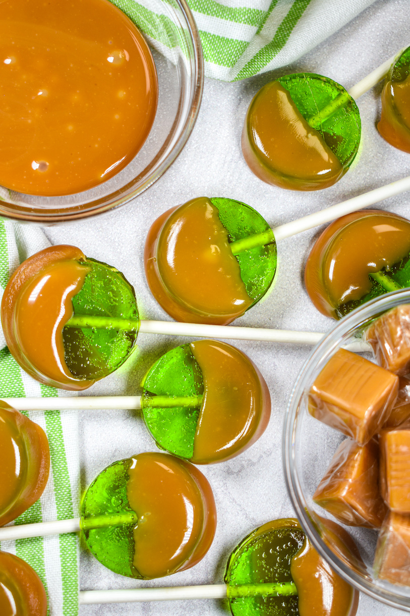 Dish of caramel and green apple lollipops dipped in caramel