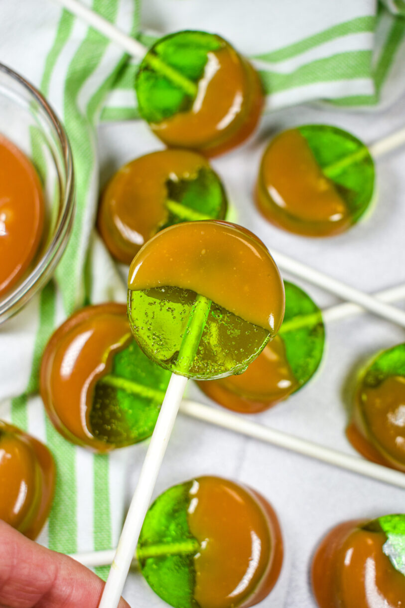 Hand holding a caramel apple sucker