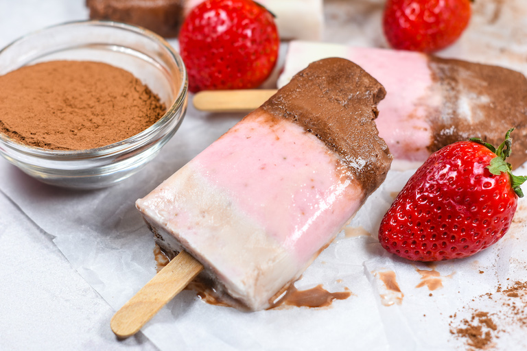 A neapolitan ice cream popsicle with a bite missing