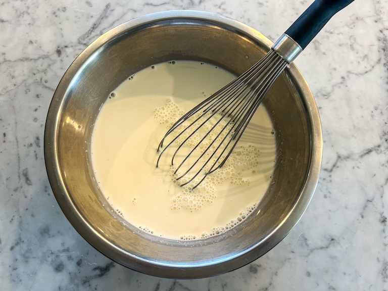 Ice cream base in a bowl with a whisk