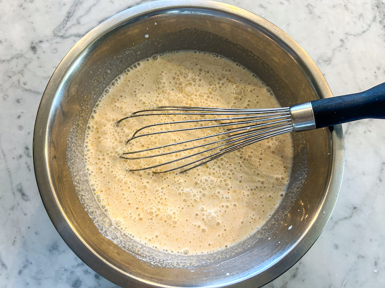 Ice cream base in a bowl with a whisk