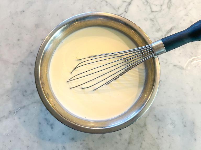 Cream in a bowl with a whisk