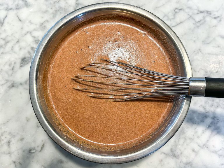 Bowl with chocolate ice cream base and whisk