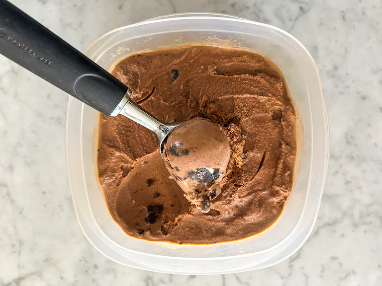 Ice cream scoop in a container of homemade ice cream