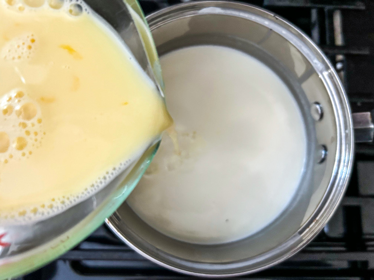 pouring tempered egg into cream