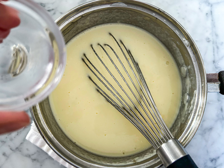 Adding vodka into coconut ice cream mixture