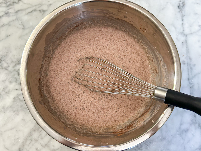 Base mixture for homemade smores ice cream in a bowl with a whisk, on a marble countertop