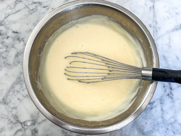 Ice cream base in a bowl with a whisk