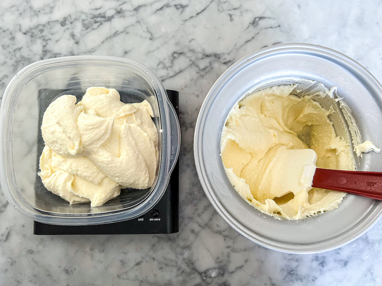 Scooping homemade white chocolate ice cream into a container