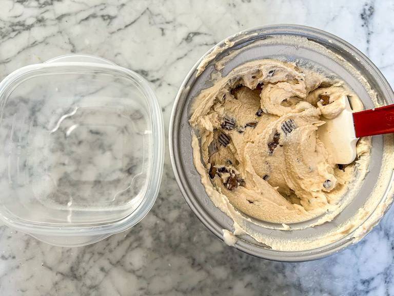 Scooping peanut butter cup ice cream into a plastic container