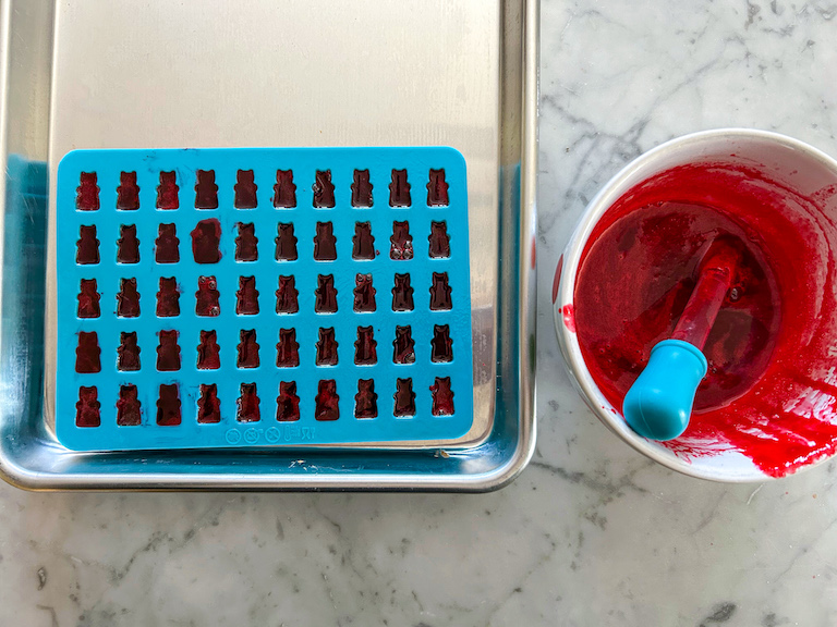 Red Jello mixture piped into a gummy bear mold