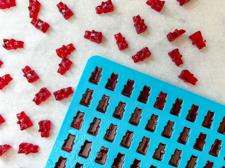 Red gummy bears surrounding mold