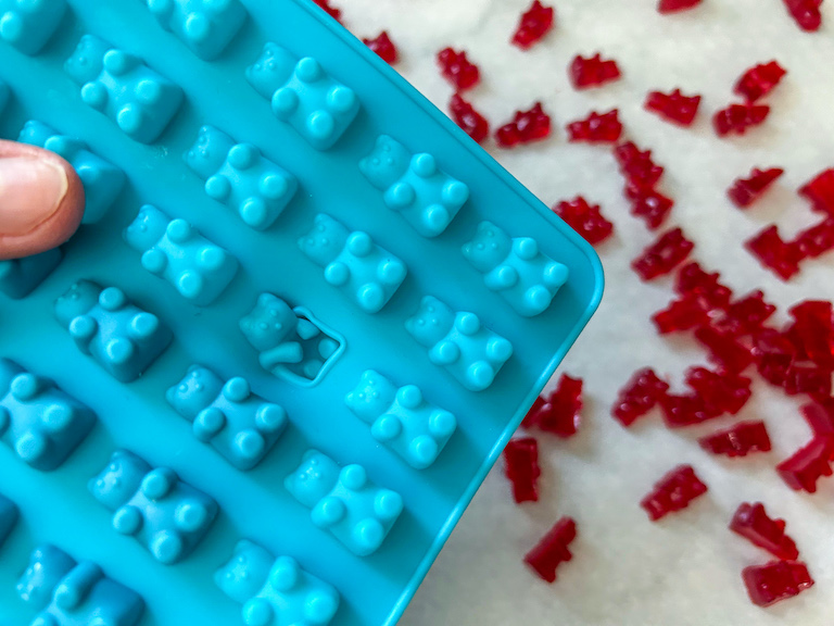 Popping red gummy bears from a silicone mold