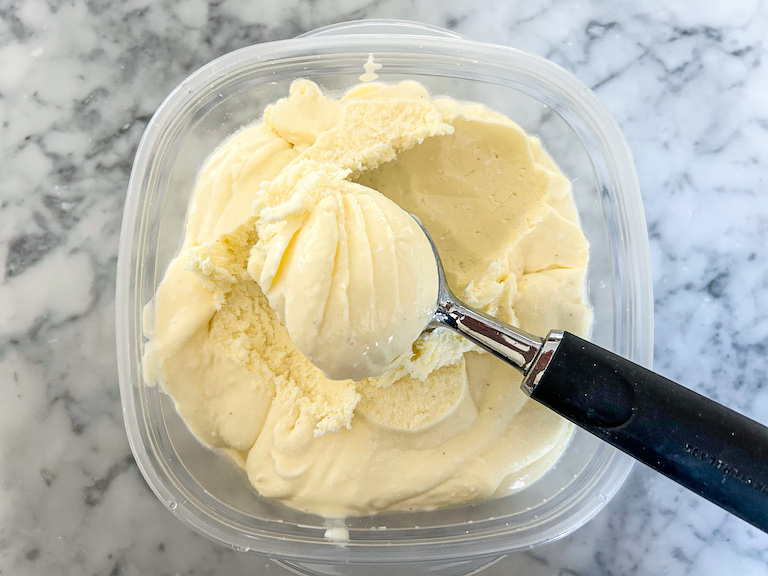 Ice cream scoop in a container of coconut ice cream