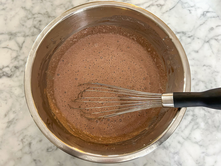 Chocolate ice cream base in a bowl with a whisk