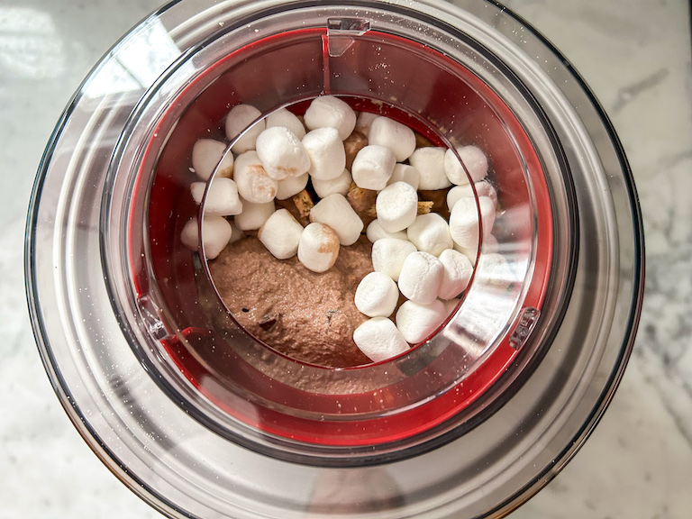 Mixing marshmallows into chocolate ice cream base in an ice cream maker