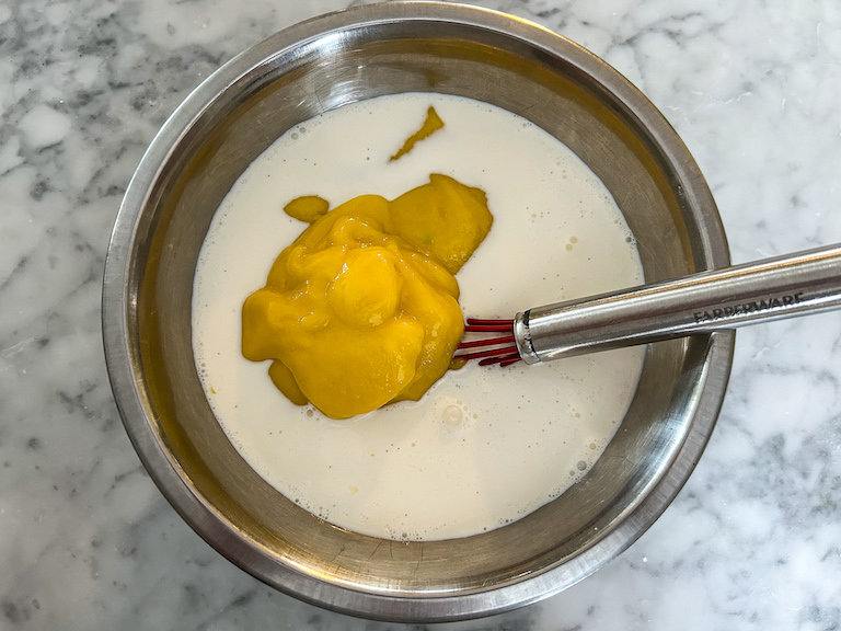 Adding mango puree to ice cream base