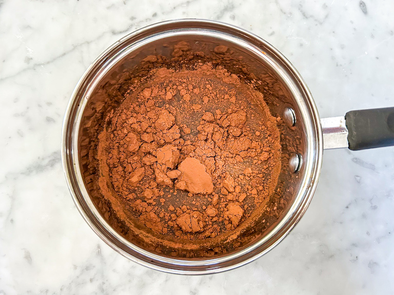 Cocoa powder, water, and sugar in a saucepan