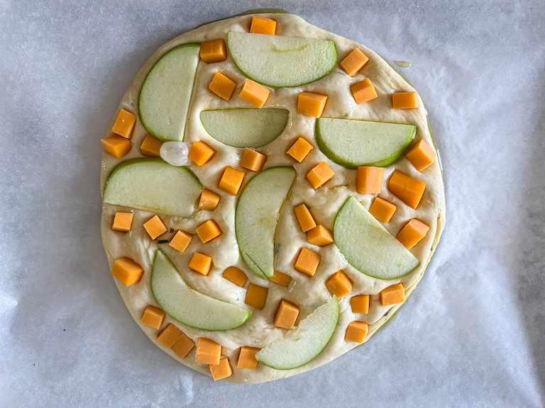 Focaccia dough topped with apples and cheese