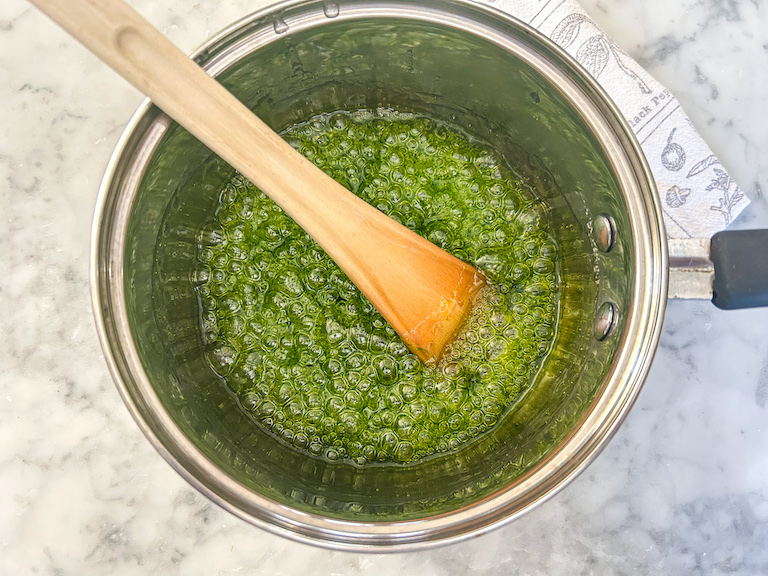 Green sugar syrup in a pan with a spoon