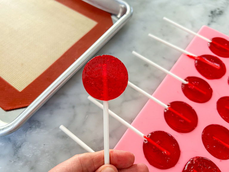 Hand holding a red lollipop