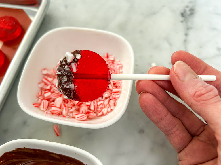 Dipping a lollipop in crushed peppermint candy