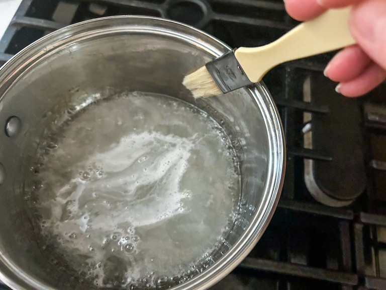 Brushing down pan with water