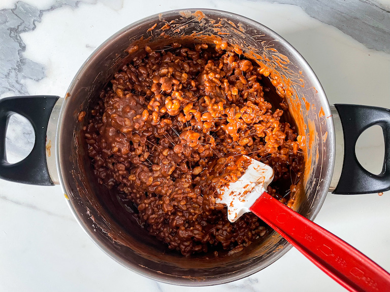 Nutella, marshmallows, and puffed rice cereal stirred together in a pot