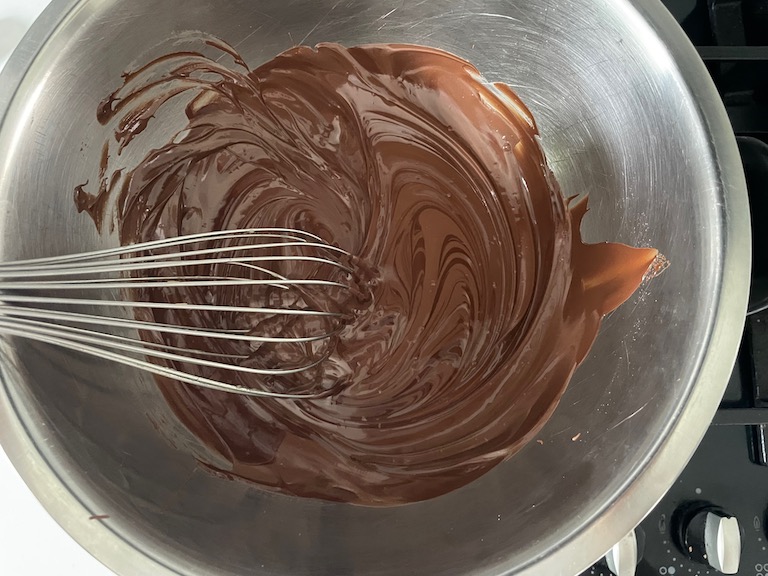 Nutella ganache in a bowl with a whisk