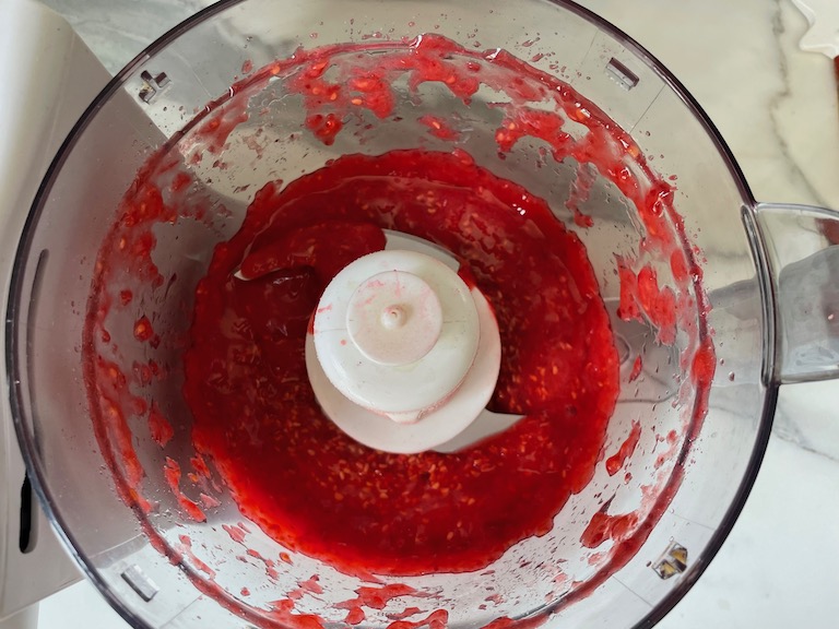 Pureed raspberries in a food processor