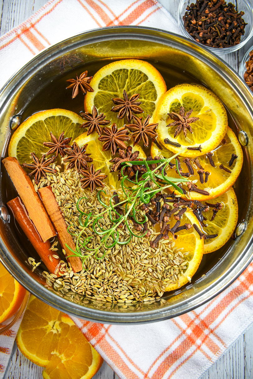 Horizontal shot of an orange simmer pot on a white surface