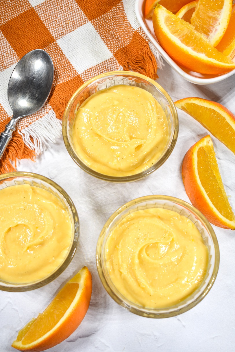 dishes of orange curd surrounded by orange slices