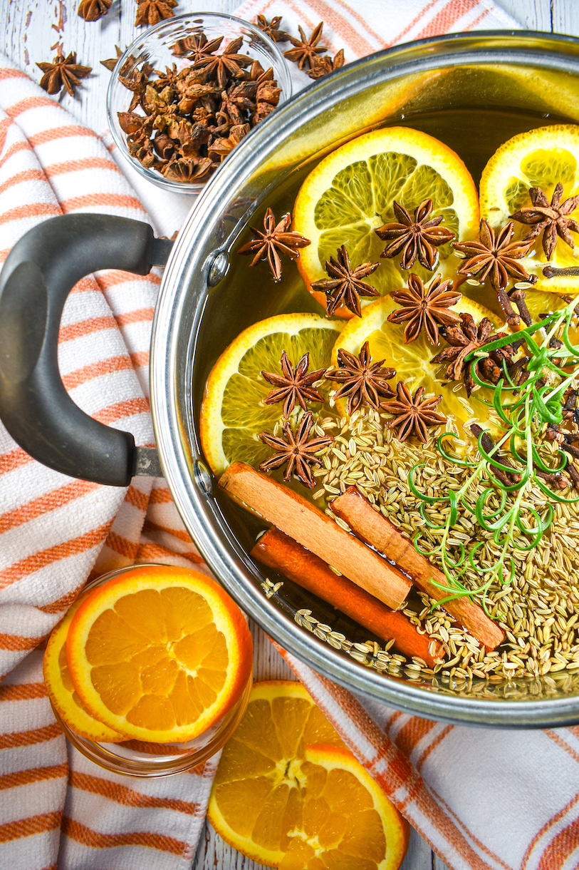 Simmer pot surrounded by star anise and sliced oranges